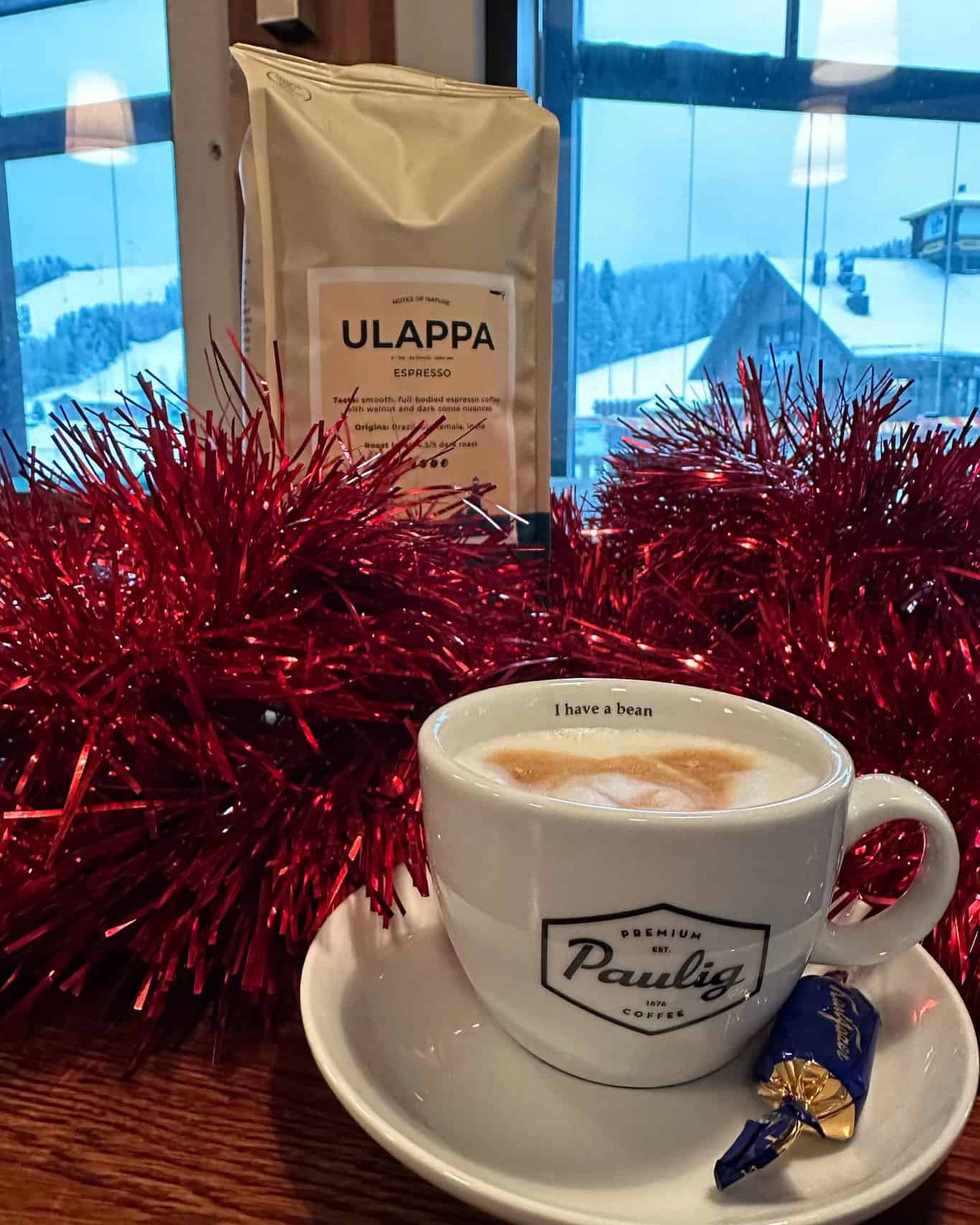 Cappuccino suklaakonvehdilla katettuna koristeltuun pöytään.